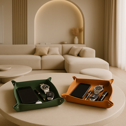 green and orange leather tray holding phones, wachtes and keys, standing on a table in a luxurious white living room